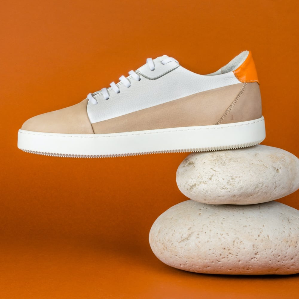 A pair of white sneakers resting on a stack of rocks, creating a contrasting and balanced composition.